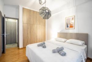 a bedroom with a large white bed with two pillows at Modern Pagrati - Greecing in Athens