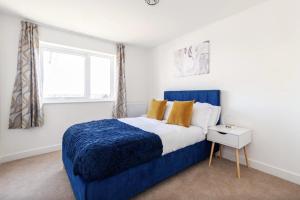 a bedroom with a blue bed and a window at Luxury Modern 2 Bed Apartment in Ebbsfleet - 20mins from London in Swanscombe