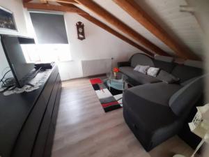 a living room with a couch and a flat screen tv at Ferienwohnung an der Singold 