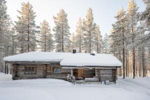 a log cabin with snow on the roof at Villa Poronperä in Kuusamo