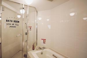 福岡市にあるZONK HOTEL Nakasuのバスルーム(シャワー、バスタブ、シンク付)
