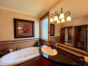 a large bathroom with a tub and a sink at Bella Vita Estate Luxury Home With Hot Tub on Golf Course in Baker City +68 photos