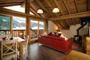 uma sala de estar com um sofá vermelho e uma mesa em Chalet de 3 chambres a Les Allues a 500 m des pistes avec terrasse et wifi em Les Allues