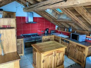 a kitchen with wooden cabinets and a red wall at Chalet de 3 chambres a Les Allues a 500 m des pistes avec terrasse et wifi in Les Allues