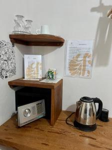 a microwave and a tea kettle on a wooden table at Pousada Lanea Experience in Atins