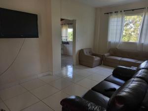 uma sala de estar com um sofá e uma televisão de ecrã plano em Casa em sítio à beira do Rio Piracicaba c/ piscina em São Pedro