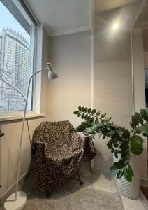 a room with a chair and a lamp and a plant at Dostyk in Almaty