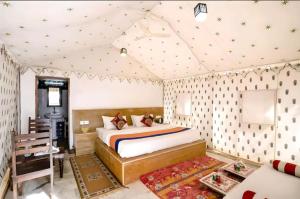 a bedroom with a bed in a tent at Ozaki Desert Camp in Jaisalmer