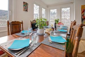 uma sala de jantar com uma mesa de madeira com guardanapos azuis em Familienglück im Schwarzwaldhaus mit Schlossblick em Neuenbürg
