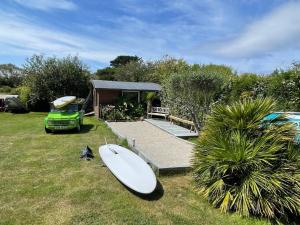 uma prancha de surf sentada na relva em frente a uma casa em Villa de 3 chambres avec piscine privee terrasse et wifi a Landunvez em Landunvez