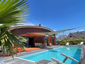 uma piscina em frente a uma casa em Villa de 3 chambres avec piscine privee terrasse et wifi a Landunvez em Landunvez