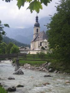 una iglesia con un puente frente a un río en Ferienhaus Amrhein, en Siegsdorf