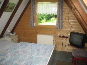 Dormitorio con cama y TV en una cabina en Ferienhaus Amrhein, en Siegsdorf