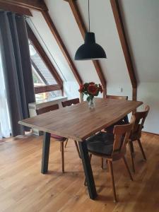 錫格斯多夫的住宿－Ferienhaus Amrhein，一张带椅子的木桌和花瓶