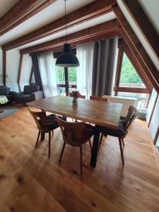 una mesa de madera y sillas en la sala de estar. en Ferienhaus Amrhein, en Siegsdorf