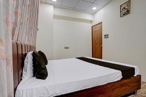 een slaapkamer met een bed en een houten deur bij Super OYO Hotel Orange in Surat