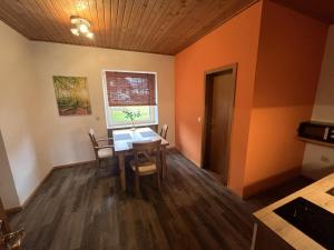 ein Esszimmer mit orangefarbenen Wänden sowie einem Tisch und Stühlen in der Unterkunft Apartments Am Kirchkogel "Ländliche Entspannung im Herzen der Steiermark" in Pernegg an der Mur