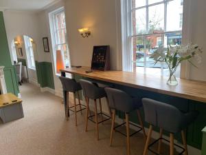 a bar with stools in a room with a window at Abbots Mead Hotel in Shrewsbury