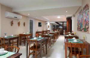 une salle à manger avec des tables et des chaises en bois dans l'établissement Pousada Bahia Bacana, à Morro de São Paulo