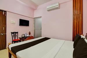 a hotel room with a bed and a chair at OYO Mahalaxmi lodge in Cuttack