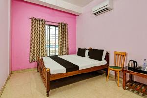 a bedroom with a bed and a table and a window at OYO Mahalaxmi lodge in Cuttack