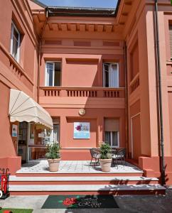 ein Gebäude mit zwei Topfpflanzen davor in der Unterkunft Hotel Delle Rose in San Bartolomeo al Mare