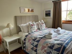 a bedroom with a bed with towels on it at Drumguish Cottage in Kingussie