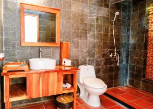 a bathroom with a toilet and a sink and a mirror at Daisy Resort in Phú Quốc