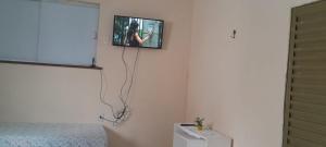a tv hanging on a wall in a bedroom at Apto em São Bráz in Belém