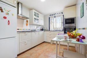 a kitchen with white cabinets and a table with fruit on it at La Casa Blanca in Corralejo