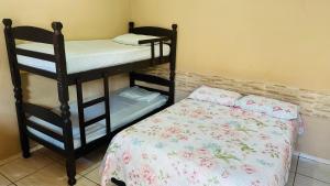 a bedroom with two bunk beds and a bed at Pousada Colorado in Olímpia