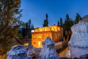a building lit up at night with snow at Downtown Hostel Leh in Leh