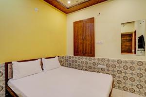 sypialnia z dużym białym łóżkiem w pokoju w obiekcie OYO Hotel Abhi Palace w mieście Dźodhpur