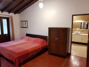 a bedroom with a bed and a dresser and a mirror at Banyan House - luxurious 4 bedroom villa on one acre, near the beach in Nagaon