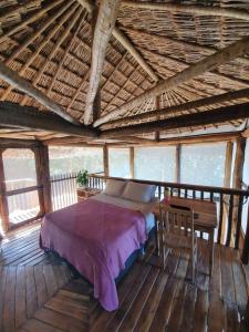 a bedroom with a bed and a wooden floor at EcoAraguaia Jungle Lodge in Caseara