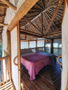 a bed in a room with a wooden ceiling at EcoAraguaia Jungle Lodge 