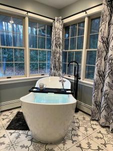 a large bath tub in a bathroom with windows at Mountain Road Lodge in Tannersville