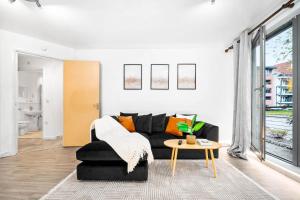 a living room with a black couch and a table at Luxury Birmingham City Centre Apartment - Balcony - Free Wifi & Netflix - Top Rated -126S in Birmingham