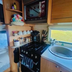 a kitchen with a stove and a sink at Kintyre Caravan in Portree