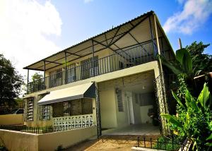 une maison avec un balcon au-dessus dans l'établissement Bayamon Puerto Rico 3 Bedroom Home, à Bayamon