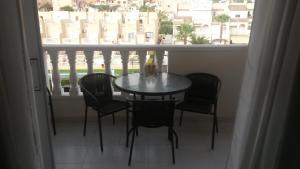una mesa y sillas en un balcón con ventana en Apartment Parquemar, en La Mata
