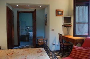 Habitación con cama, escritorio y TV. en Il Pino en Vetulonia