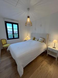 een witte slaapkamer met een groot bed en een raam bij Superbe maison neuve proche centre-ville et plage in Neufchâtel-Hardelot