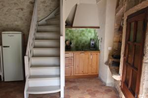 una escalera que conduce a una cocina con nevera en Le Bastidon, gîte des Lucioles en Provence, en Montségur-sur-Lauzon