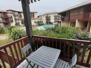 een witte stoel en een tafel op een balkon bij Appartement T2 cabine avec terrasse et piscine à Vieux-Boucau, idéal pour les vacances ! - FR-1-379-18 in Vieux-Boucau-les-Bains
