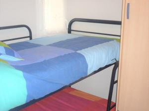 a bed with a blue comforter in a bedroom at Appartement Vieux-Boucau-les-Bains, 2 pièces, 4 personnes - FR-1-379-97 in Vieux-Boucau-les-Bains