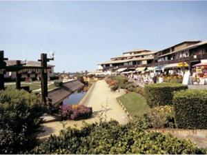 a group of people walking down a sidewalk next to a body of water at Appartement Vieux-Boucau-les-Bains, 2 pièces, 4 personnes - FR-1-379-97 in Vieux-Boucau-les-Bains