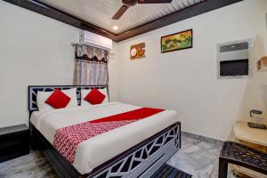 um quarto com uma cama com almofadas vermelhas em OYO Hotel SSD Grand em Pūdimadaka
