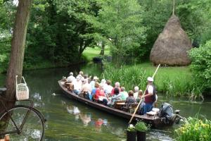 un groupe de personnes dans un bateau sur une rivière dans l'établissement 28m Ferienhaus am Rande des Spreewalds, à Bornsdorf