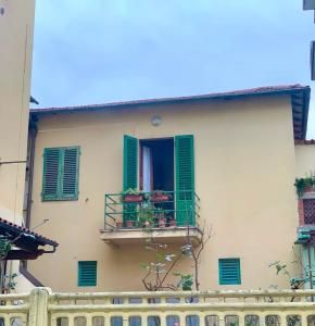 um edifício com persianas verdes e uma varanda em Appartamento Meri, Montecatini Terme em Montecatini Terme